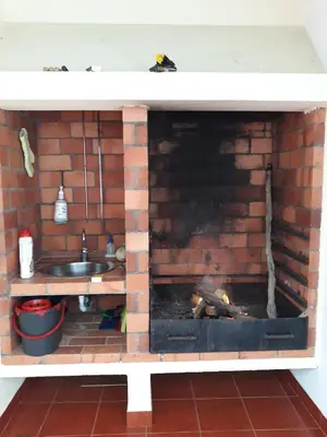 a kitchen with a brick fireplace and a sink at Apartamentos Arrifes 1 in Porto Santo