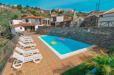 a villa with a swimming pool and lounge chairs at Vila Maria Quinta 6 