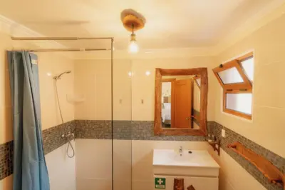 a bathroom with a shower and a sink and a mirror at Vila Maria Quinta 2 
