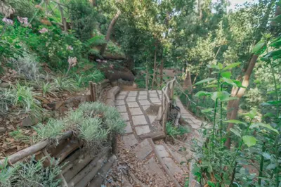 a stone path in a garden with plants and trees at Vila Maria Quinta 2 