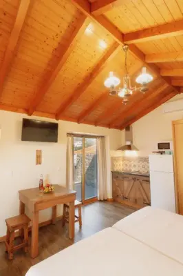 a bedroom with a bed and a table and a kitchen at Vila Maria Quinta 2 