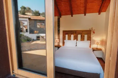 a bedroom with a bed and a sliding glass door at Vila Maria Quinta 1 