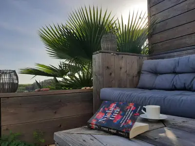 a book sitting on a table with a cup and a coffeeucer at maresoul - Ferienapartment mar in Raposeira