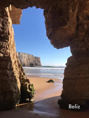 a view of a beach through a rock cave at maresoul - Ferienapartment mar in Raposeira