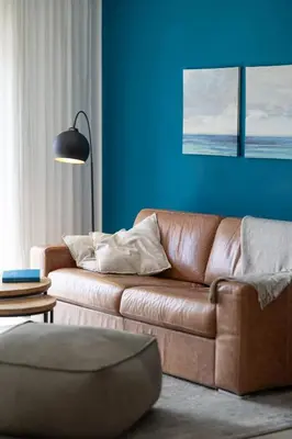 a living room with a brown couch and a blue wall at maresoul - Ferienapartment mar in Raposeira