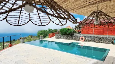 a villa with a swimming pool and a building at Madeira Sunset Cottage - Nature Retreat in Ponta do Pargo