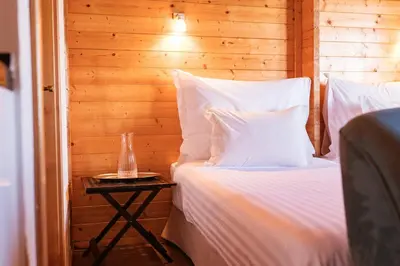 two beds with white pillows in a room at Madeira Sunset Cottage - Nature Retreat in Ponta do Pargo