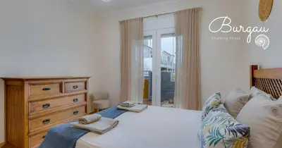 a bedroom with a bed and a dresser and a window at Burgau Charming House Villa in Burgau