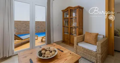 a living room with a table and a chair at Burgau Charming House Villa in Burgau