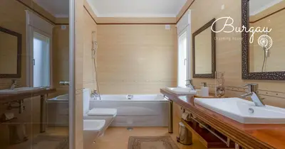 a bathroom with two sinks and a tub and a toilet at Burgau Charming House Villa in Burgau