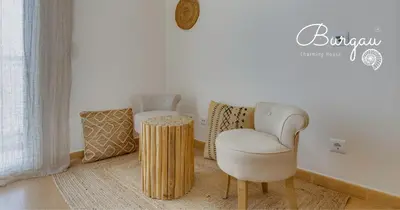 a living room with a chair and a table at Burgau Charming House Villa in Burgau