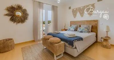a bedroom with a bed with a blue blanket at Burgau Charming House Villa in Burgau
