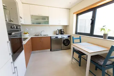 a kitchen with a table and a table and chairs at Casa Kama in Raposeira