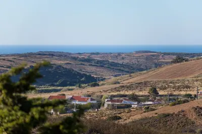 a village on a hill with the ocean in the background at Casa Kama in Raposeira