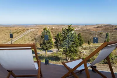 a pair of chairs on a deck with a view at Casa Kama in Raposeira