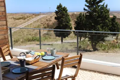 a wooden table with a basket of food on a balcony at Casa Kama in Raposeira