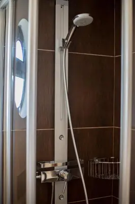 a shower head in a bathroom with a mirror at Casa Kama in Raposeira