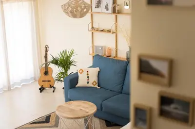 a blue couch in a living room with a guitar at Casa Kama in Raposeira