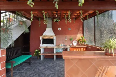 an outdoor patio with a fireplace and a bench at O Meu Sonho in Calheta