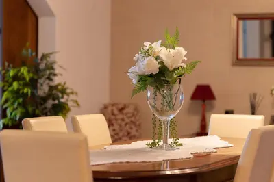 a vase of white flowers sitting on a table at O Meu Sonho in Calheta
