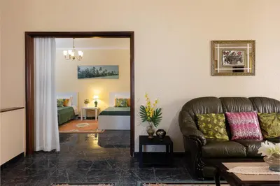 a living room with a leather couch and a bedroom at O Meu Sonho in Calheta