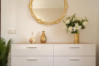 a white dresser with a mirror and flowers on it at O Meu Sonho in Calheta