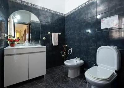 a bathroom with a toilet and a sink and a mirror at O Meu Sonho in Calheta