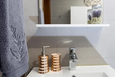 a bathroom sink with aaucet and two cups on it at Antonella Home Funchal in Funchal