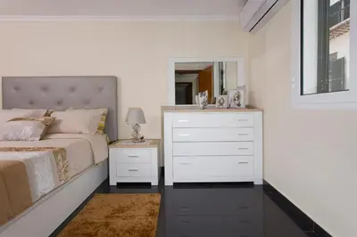 a bedroom with a bed and a dresser with a mirror at Antonella Home Funchal in Funchal