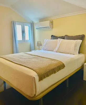 a bedroom with a large bed with a window at Antonella Home Funchal in Funchal