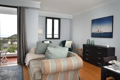 a living room with a couch and a balcony at São Martinho, a Home in Madeira in Funchal