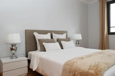 a white bedroom with a large white bed with two lamps at São Martinho, a Home in Madeira in Funchal