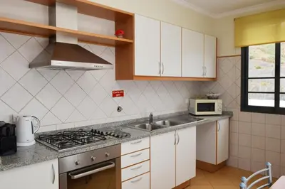 a kitchen with a sink and a stove top oven at São Martinho, a Home in Madeira in Funchal