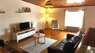 a living room with a couch and a tv at Casa d'Avó in Carrapateira
