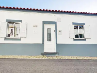 a white building with two windows and a door at Casa d'Avó in Carrapateira