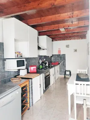 a kitchen with white cabinets and a counter top at Casa d'Avó in Carrapateira