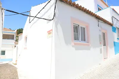 a white house with a window on a street at Salema Beach Home in Salema