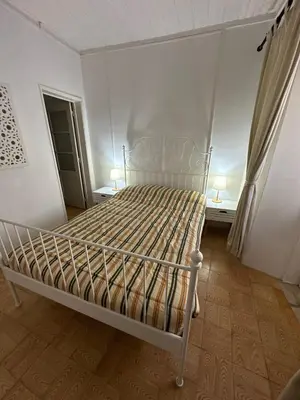 a white bed in a room with two lamps at Salema Beach Home in Salema