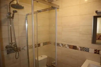 a bathroom with a glass shower with a toilet at Salema Beach Home in Salema