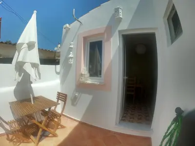a room with chairs and a table and a mirror at Salema Beach Home in Salema