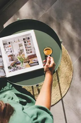 a person sitting at a table with a book and a cup of coffee at Casa LNNoa Boutique Room whit private pool in Lagos