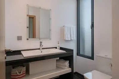 a bathroom with a sink and a mirror at Vila Papagaio Verde by An Island Apart in Funchal