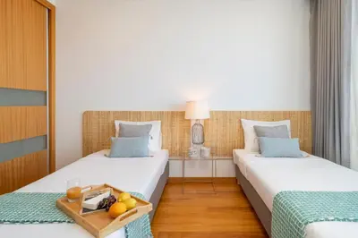 two beds in a hotel room with a tray of fruit at Vila Papagaio Verde by An Island Apart in Funchal