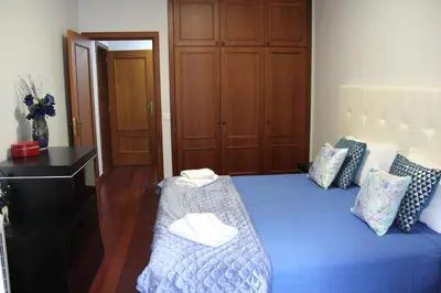 a bedroom with a blue bed with two towels on it at Doca do Cavacas Apartment in Funchal