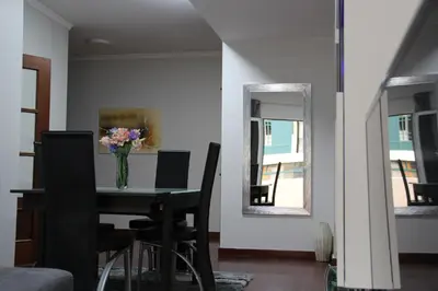 a dining room with a table with a vase of flowers on it at Doca do Cavacas Apartment in Funchal