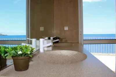 two sinks in a bathroom with a view of the ocean at The Artist Villa in Santa Cruz