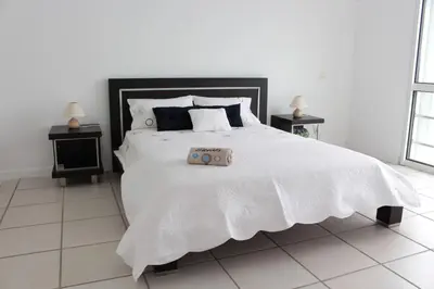 a bedroom with a white bed with a suitcase on it at The Artist Villa in Santa Cruz