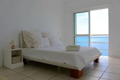 a bed in a room with a large window at The Artist Villa in Santa Cruz