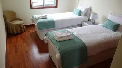 a white chair sitting next to a white table at Forum Madeira Ajuda Apartment in Funchal