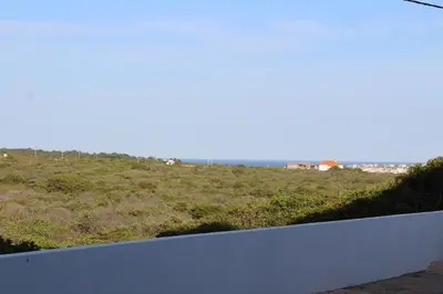 a view of a grassy hill with a white wall at Beach Front Apartment 2 in Sagres